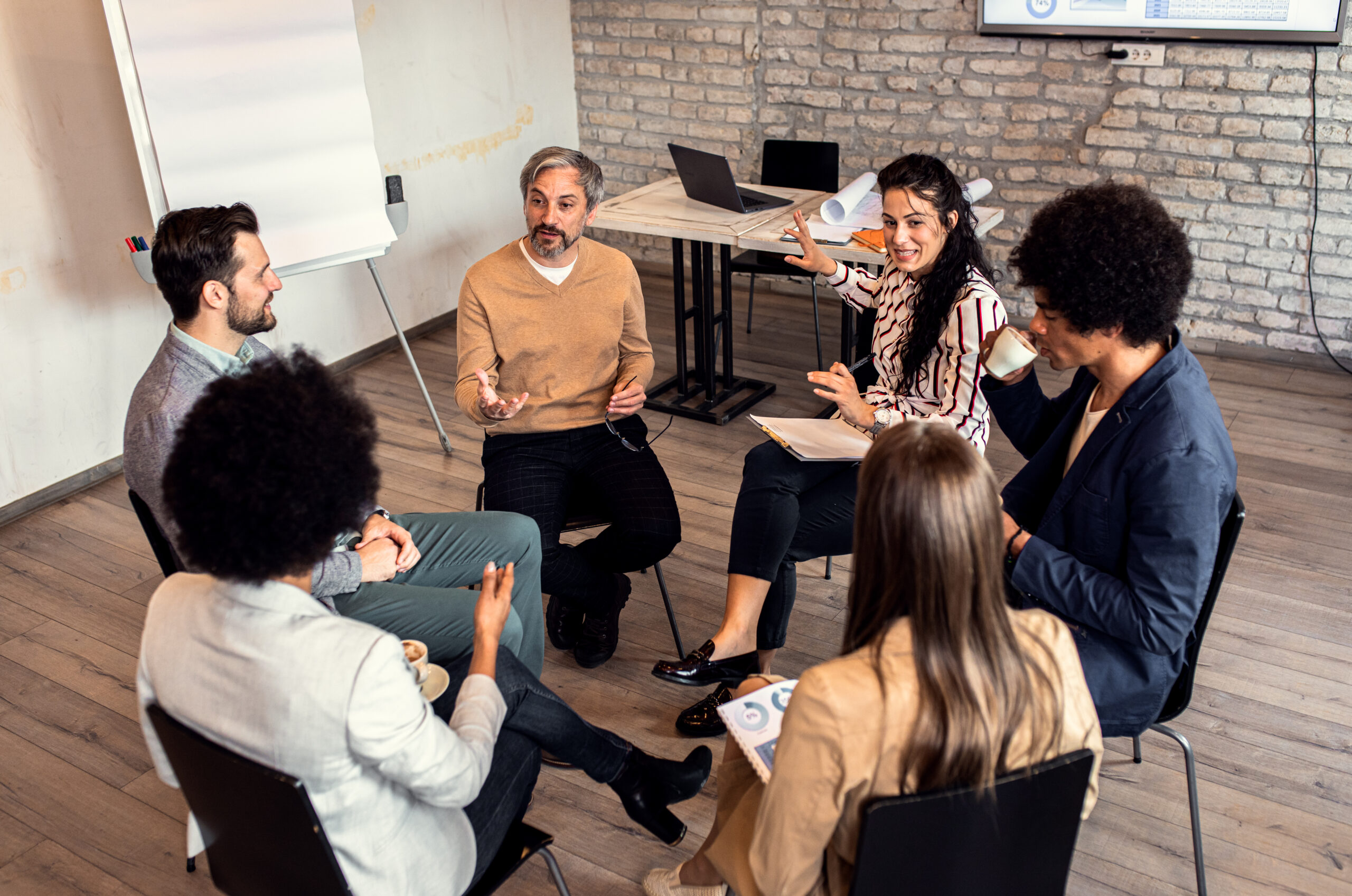 Group of diverse group of business people having a meeting while sitting in circle.